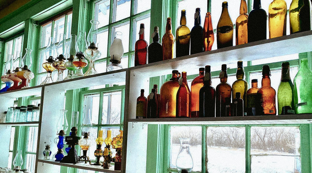 Bottles on shelves in front of windows
